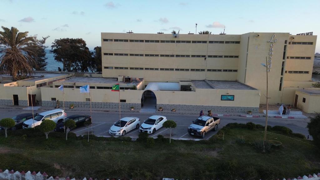 a parking lot with cars parked in front of a building at LeCansado in Nouadhibou