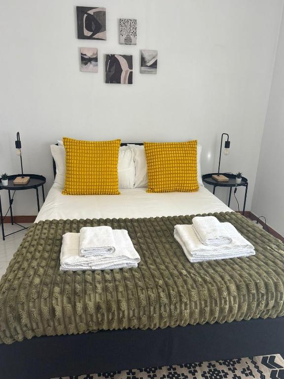 a bedroom with a bed with two towels on it at Setúbal Sunset Apartment in Setúbal