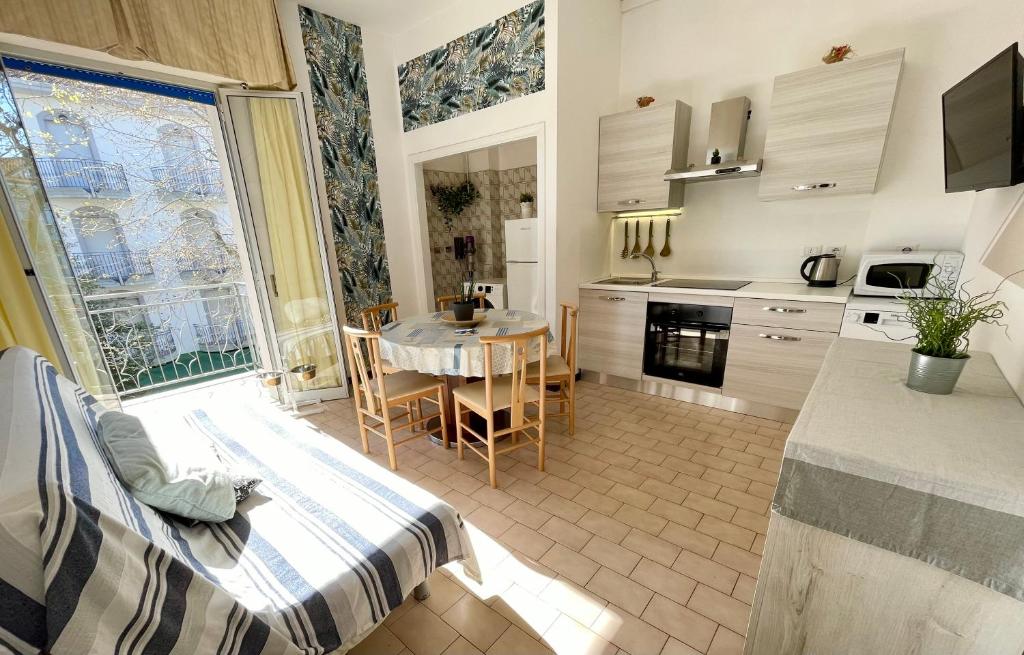 a kitchen with a table and a dining room at PetlyApartments in Bellaria-Igea Marina