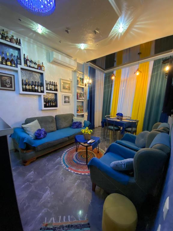 a living room with blue couches and a table at Dea Apartments in Batumi