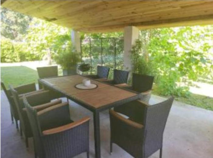 a wooden table and chairs on a patio at Villa cosy in Biganos