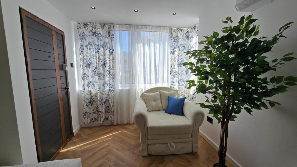 a living room with a chair and a window at Sea Nest in Šušanj