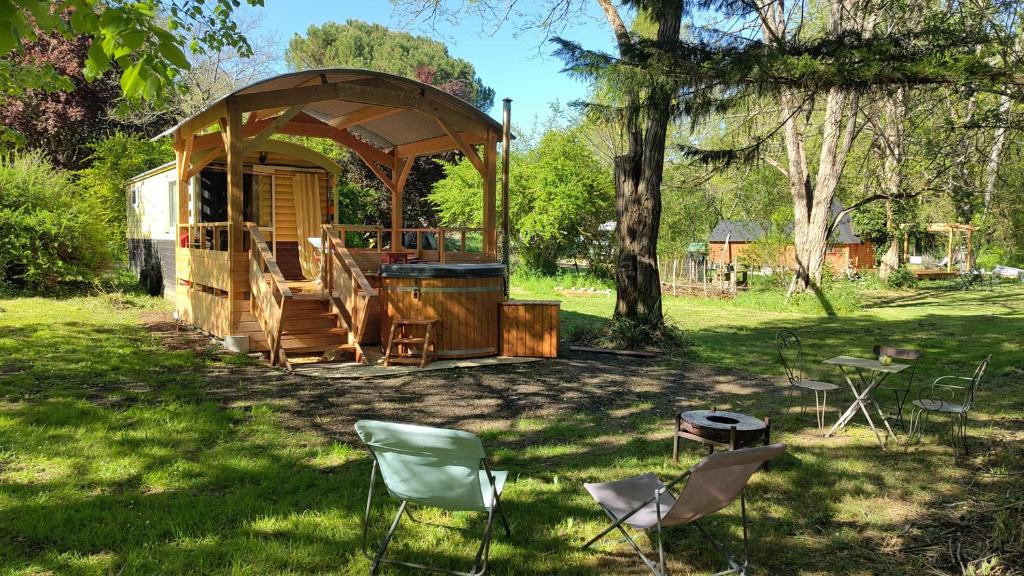a gazebo in a yard with chairs in the grass at Graines de nature - Ecolodges Insolites in Saint-Eutrope-de-Born
