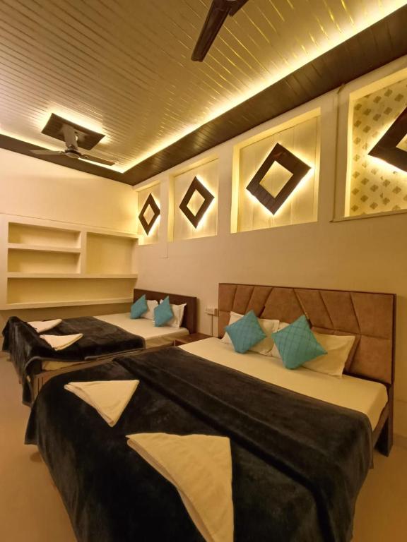 two beds in a hotel room with blue pillows at The Mystery Hostel in Varanasi