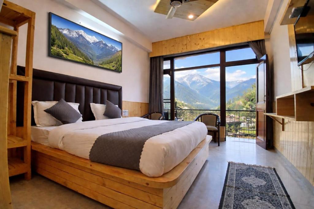 ein Schlafzimmer mit einem großen Bett und einem großen Fenster in der Unterkunft Hotel Cloud Hills in Dharamsala