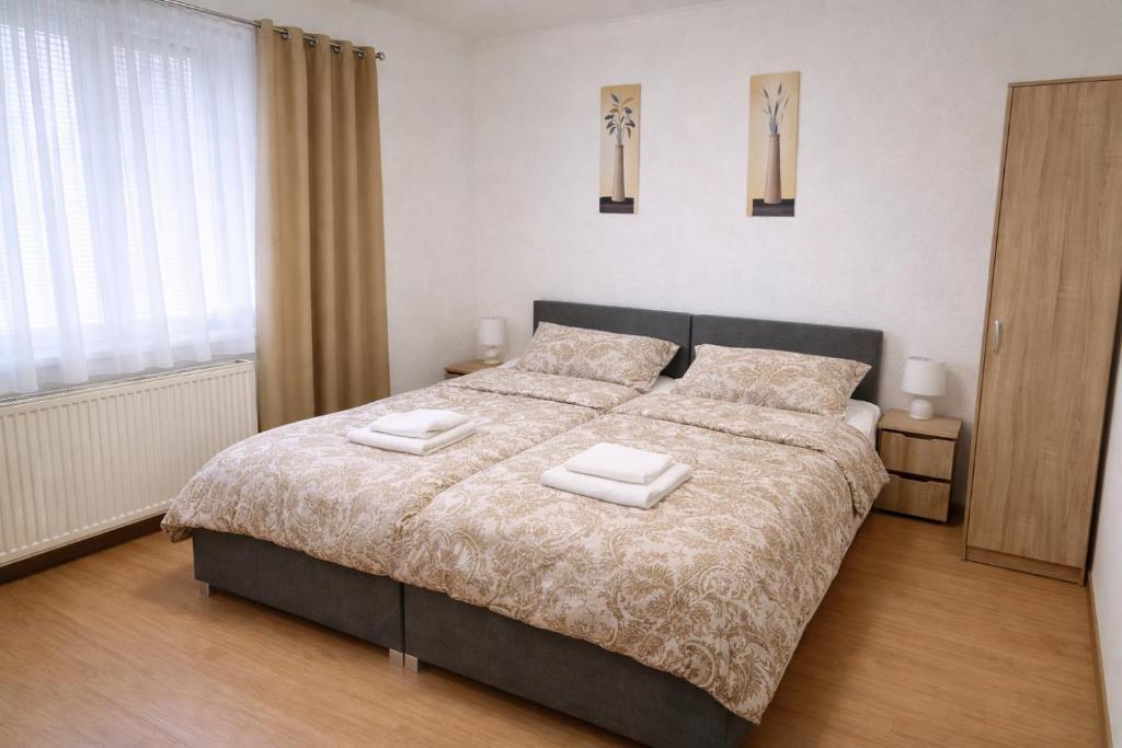 a bedroom with a bed with two towels on it at Penzion Lea in Diakovce