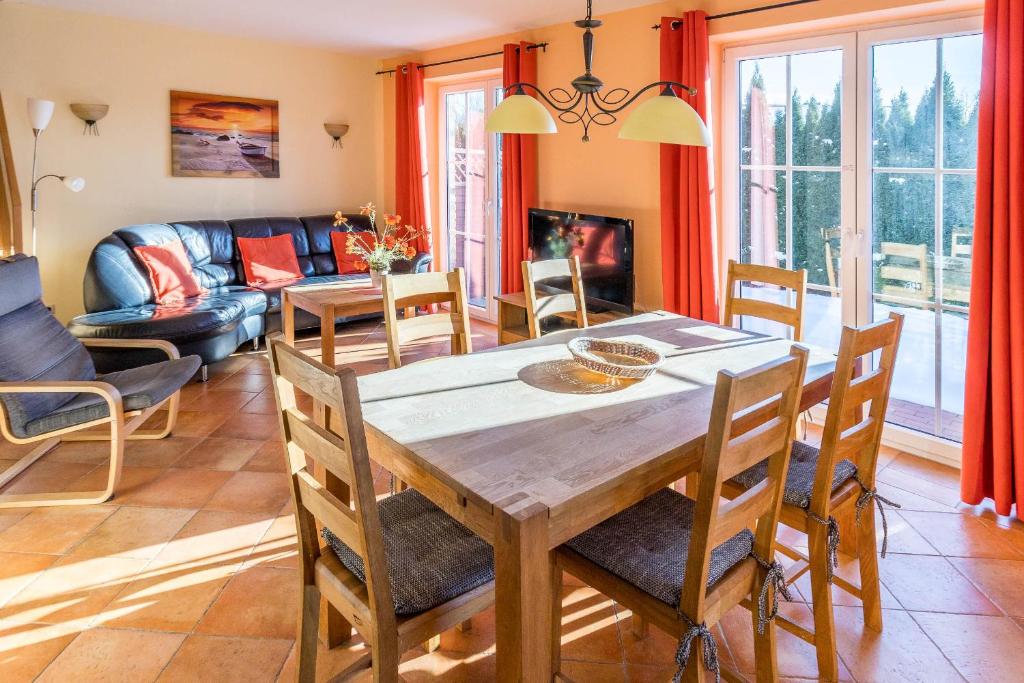 a dining room with a table and chairs and a couch at Ferienhaus Sandra in Wohlenberg