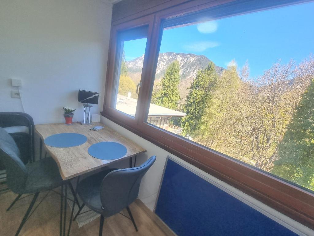 a room with a table and chairs and a large window at Rax-Basecamp 24 in Reichenau