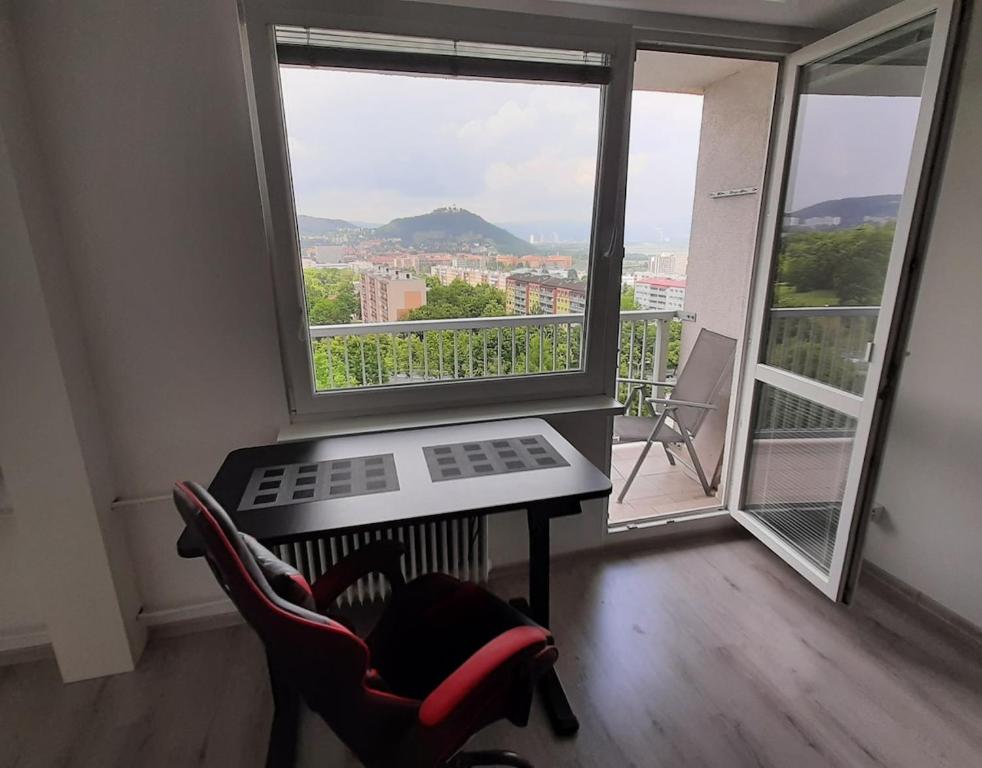 a room with a table and chairs and a large window at Apartmán s balkonem in Most