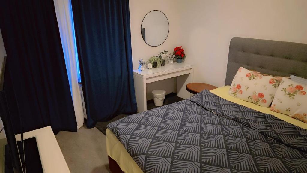 a small bedroom with a bed and a mirror at Station Stay Örebro in Örebro