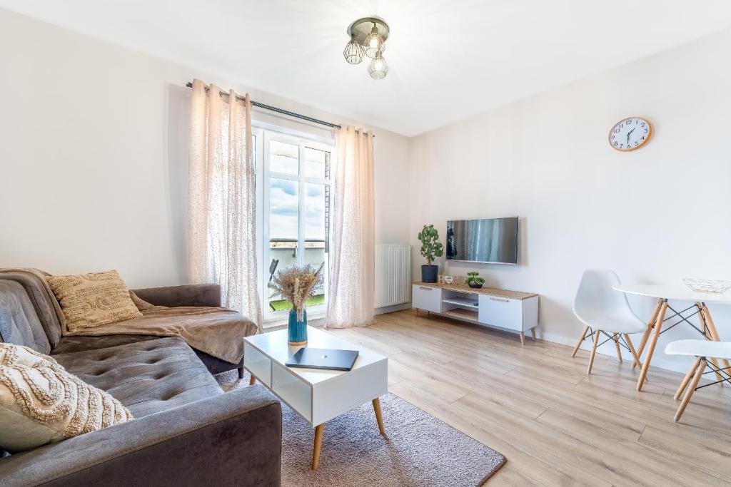 a living room with a couch and a table at Apartament Pirat in Ostróda