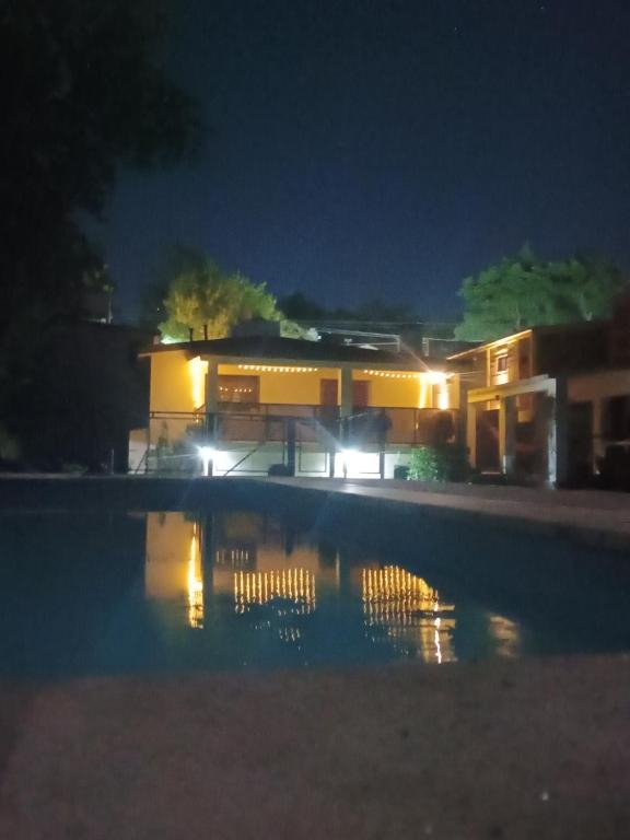 a building at night with a pool in front of it at Quimelco casa de campo in La Granja