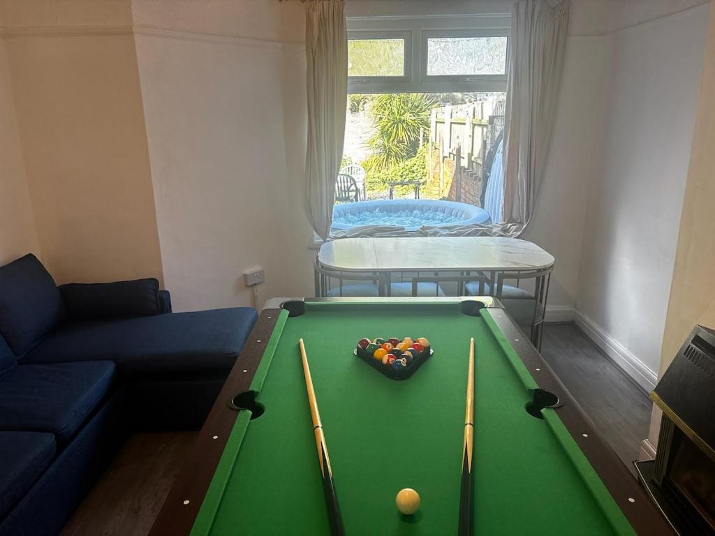 a living room with a pool table with cue balls at Tranquil Hideaway with Hot Tub and Pool Table in Cardiff