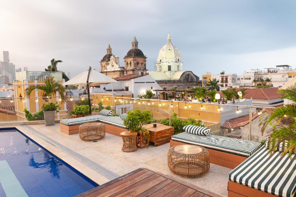 a rooftop patio with a pool and tables and chairs at Sophia Hotel By OxoHotel in Cartagena de Indias