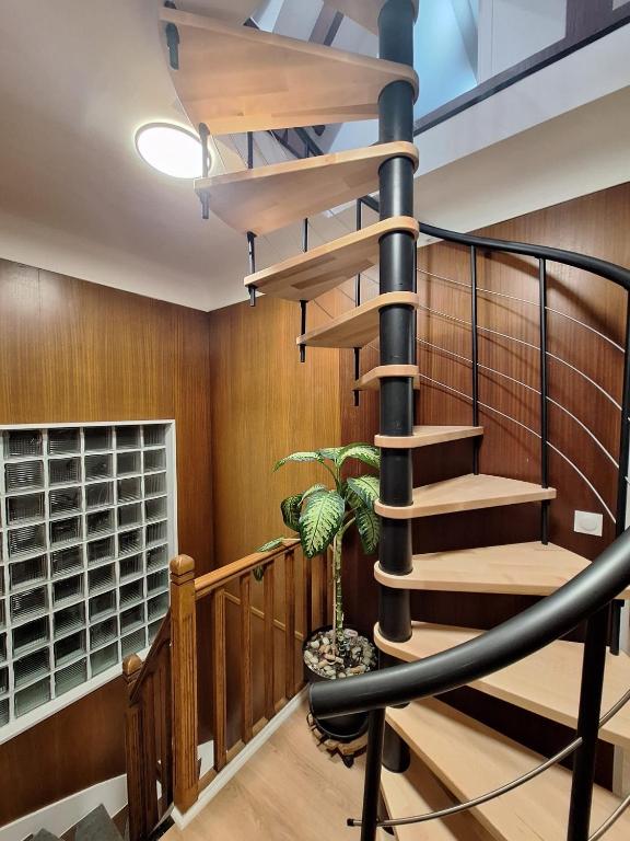 a spiral staircase in a house with a potted plant at Le GIGI in Antony