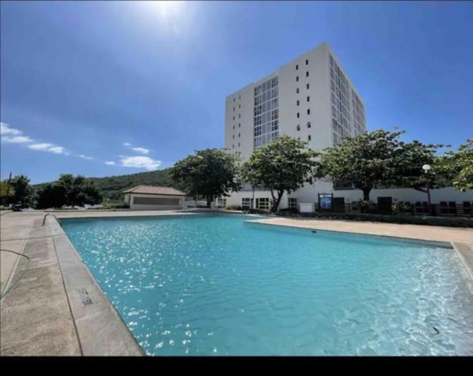 a large swimming pool in front of a building at Caribbean Staycation in Portmore
