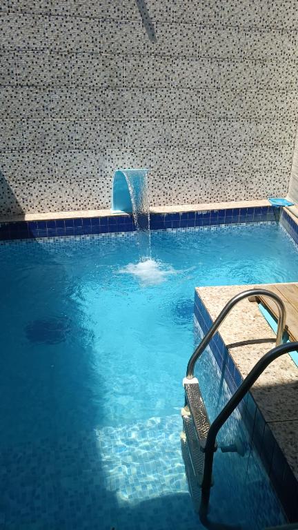 a swimming pool with a water fountain at Casa 70 Hostel 350m da praia Balneario Flamingo in Matinhos