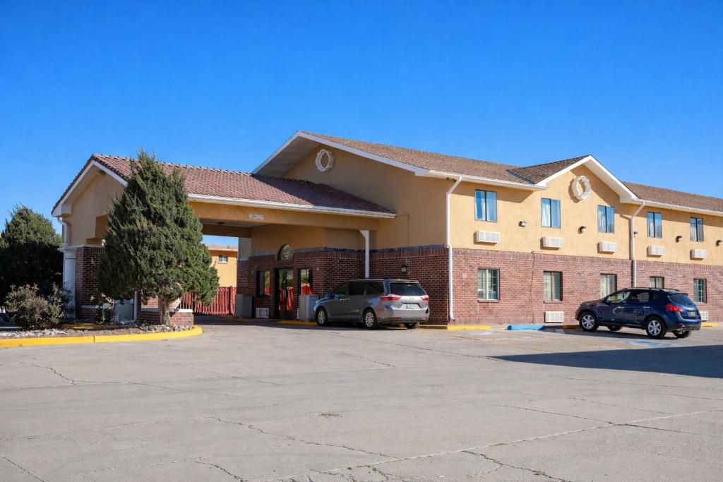 a building with two cars parked in a parking lot at Townhouse Super Gallup - I-40 in Gallup