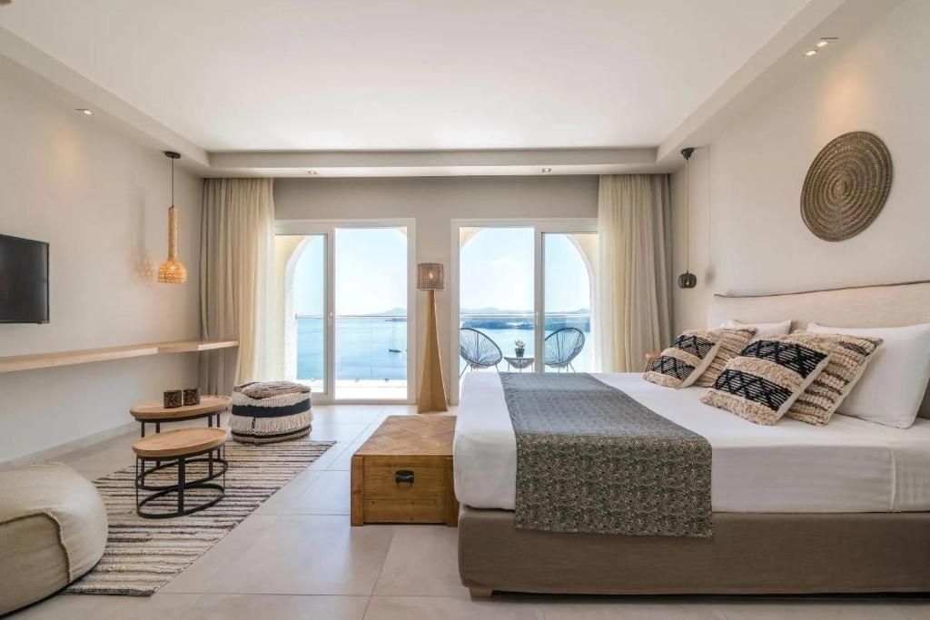 a bedroom with a large bed and a balcony at Marilena Sea View Hotel in Pyrgi
