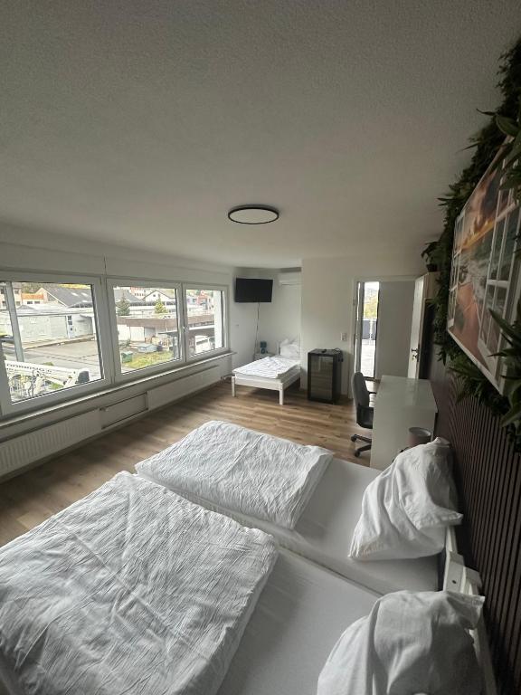 a bedroom with two large beds in a room at Gästehaus GAP in Dietlingen