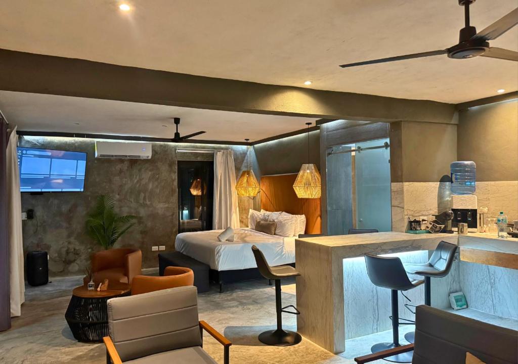 a hotel room with a bed and a living room at Rico Isla Rooms Eco-Chic in Isla Mujeres