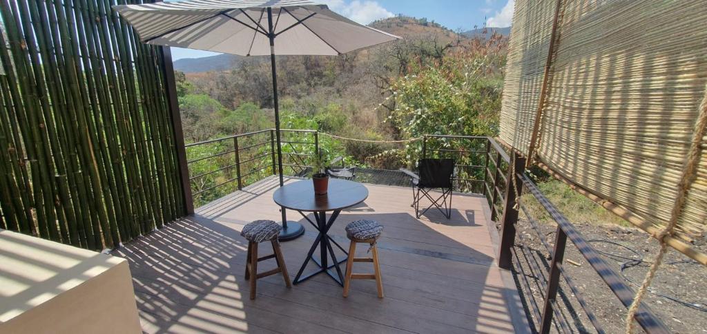 a patio with a table and chairs and an umbrella at Casa Catonalco in Xalmolonco