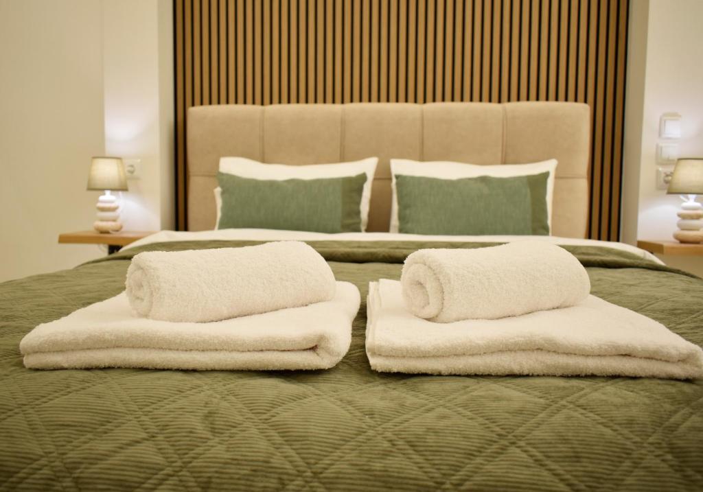 ein Schlafzimmer mit einem großen Bett, auf dem Handtücher liegen in der Unterkunft Chatzidakeio View Apartments in Xánthi