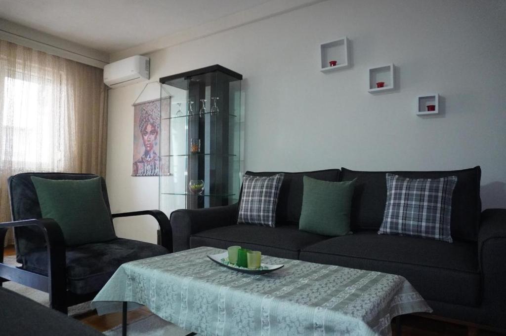 a living room with a couch and a table at Prishtina Center Apartment, 100m from Skanderbeg Square in Prishtinë
