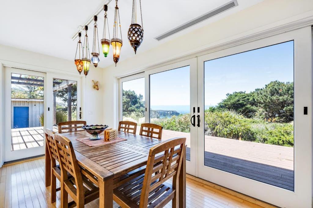 a dining room with a table and chairs and a large window at Voyagers Paradise in Gualala