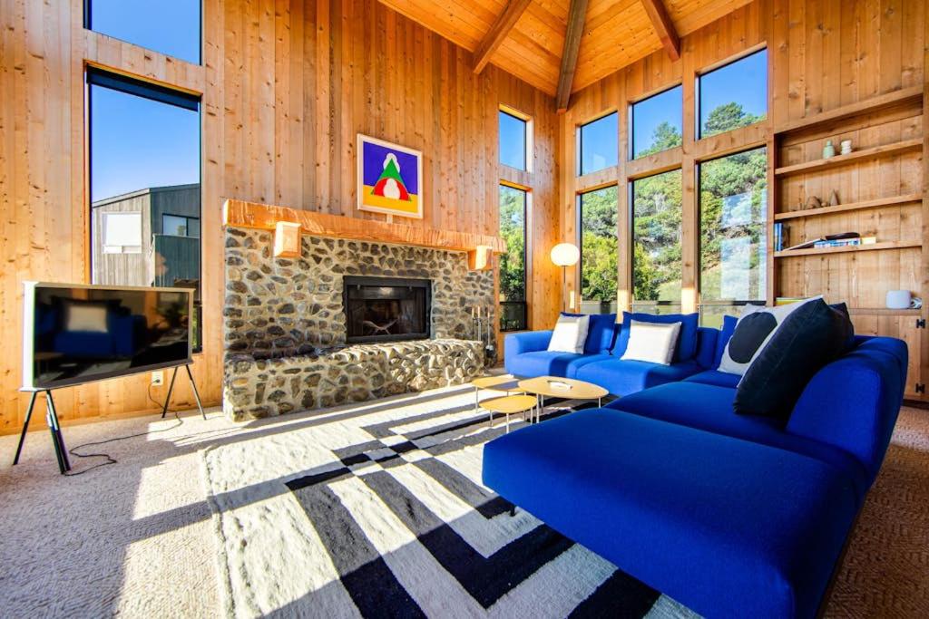 a living room with a blue couch and a fireplace at Breakers Hideaway in Sea Ranch