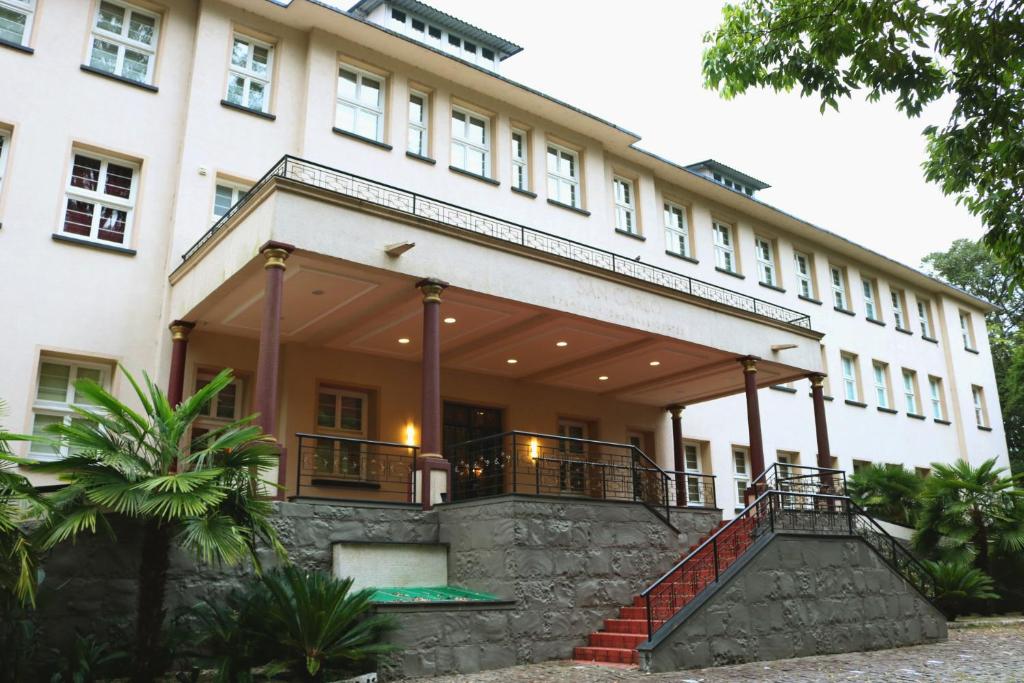 a large white building with a staircase in front of it at Villa São Carlos in Caxias do Sul