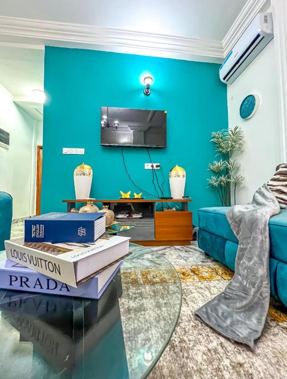 a living room with blue walls and a blue couch at Luxury lita Résidence in Yaoundé