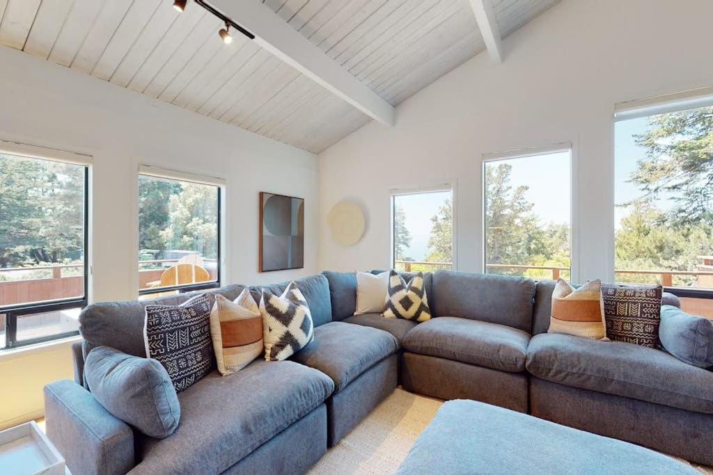 a living room with a blue couch and windows at The Great Escape in Sea Ranch