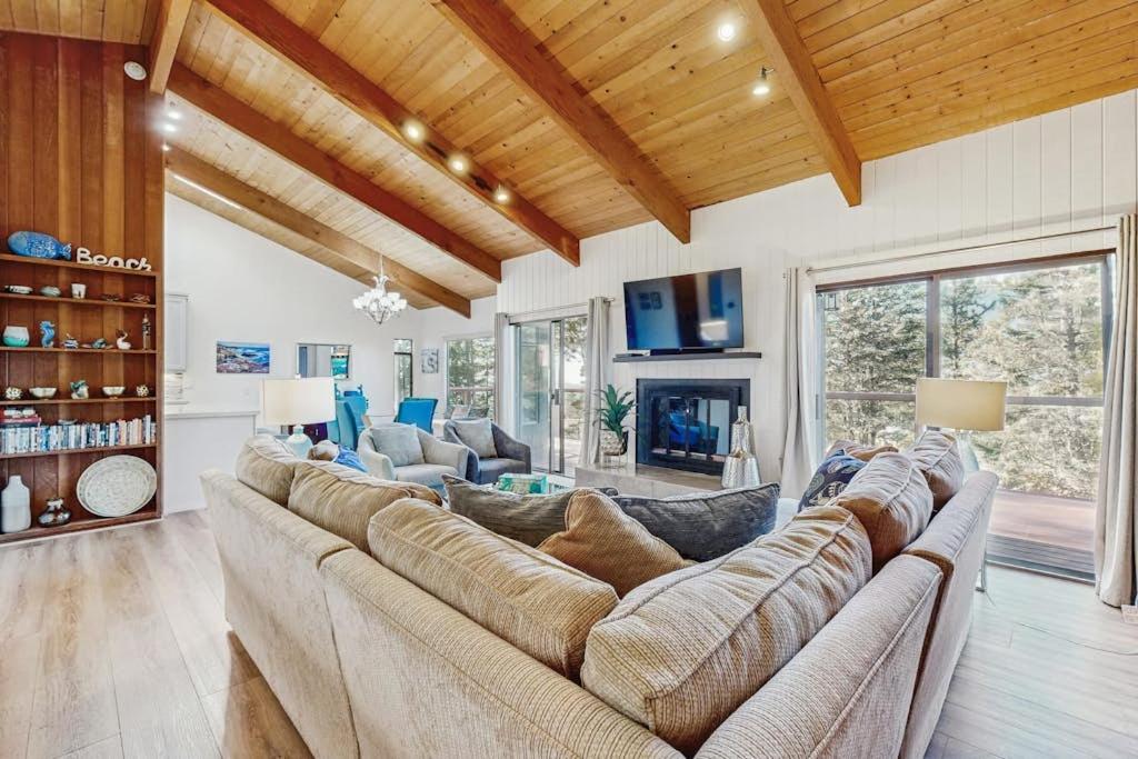 a living room with a large couch and a fireplace at Sea Raven in Gualala