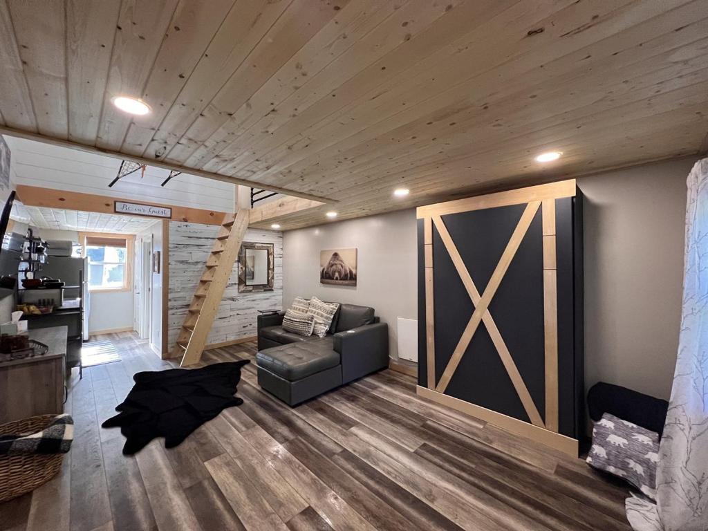 a living room with a couch and a wooden wall at Catch'em AK - Bears Den in Soldotna