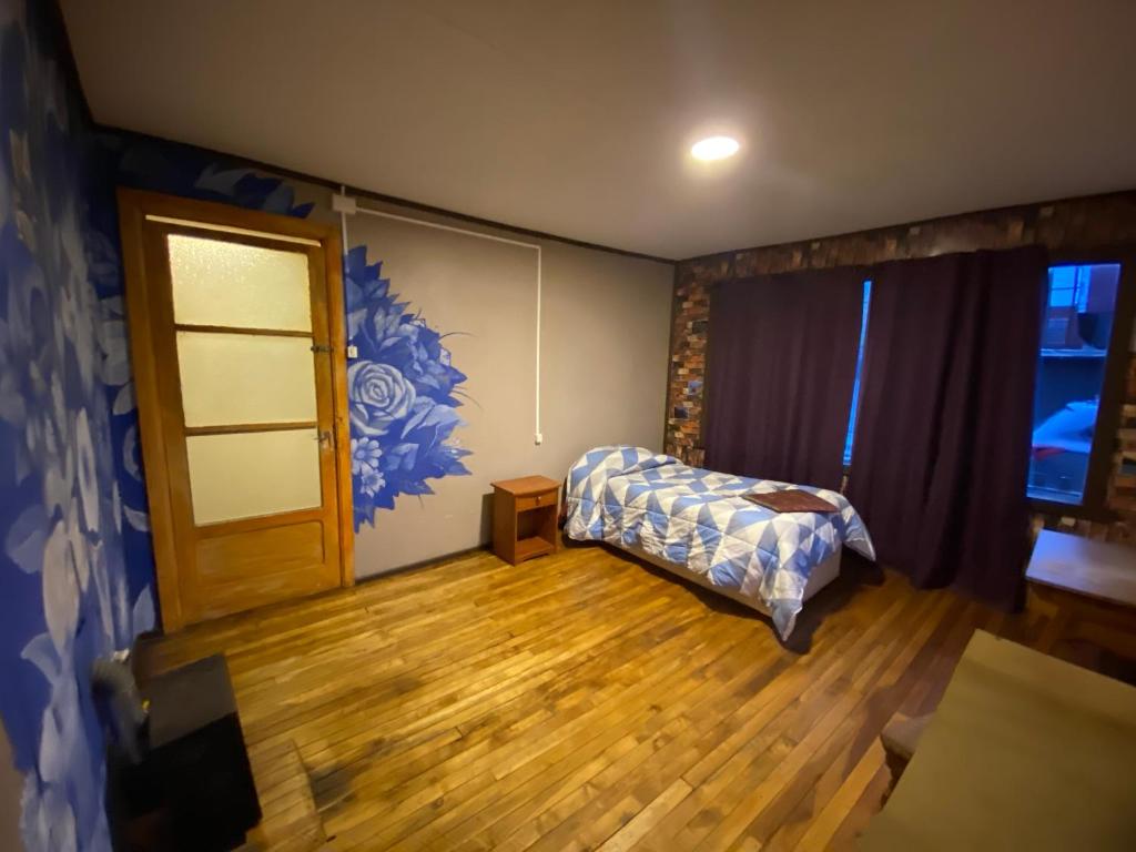 a living room with a bed and a window at ይሥሓቅ House in Puerto Natales