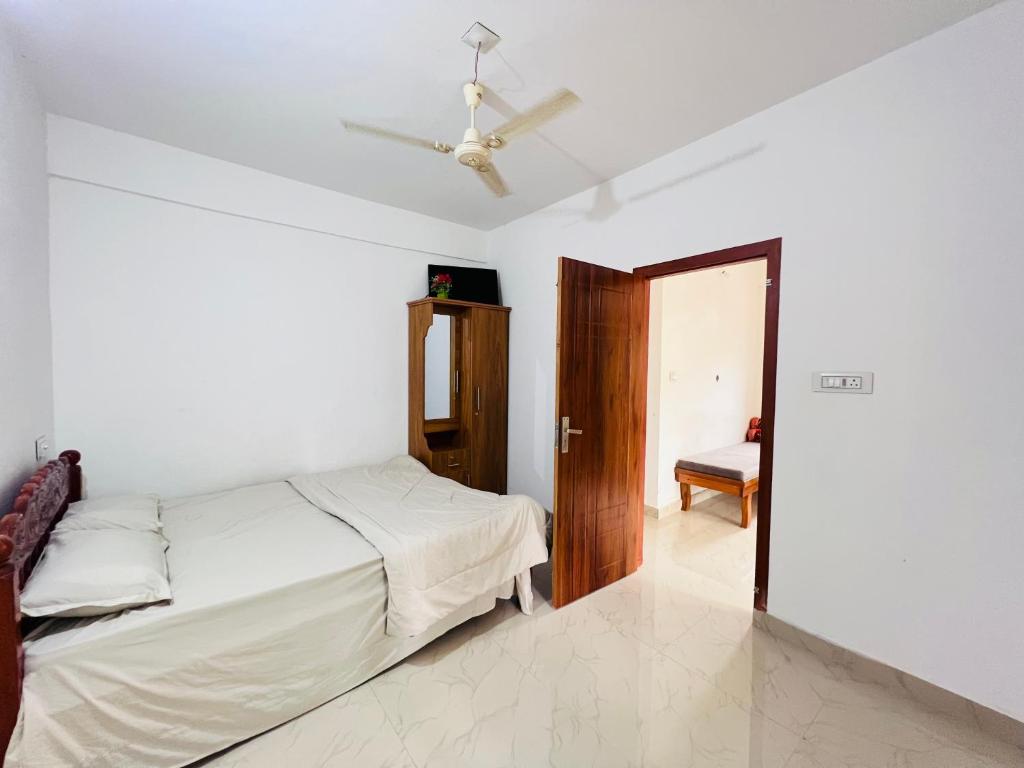 a bedroom with a bed and a ceiling fan at HiDot Holidays in Padinjarathara