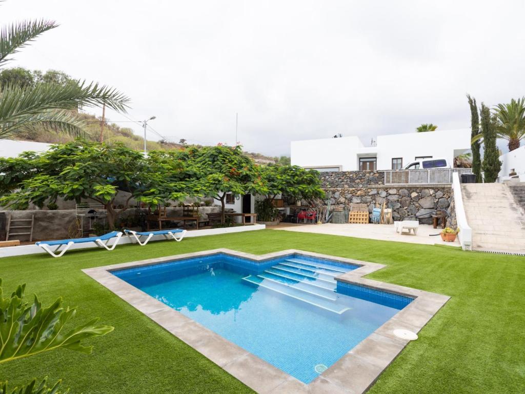 a backyard with a swimming pool and grass at Luz de Mafasca in La Hidalga