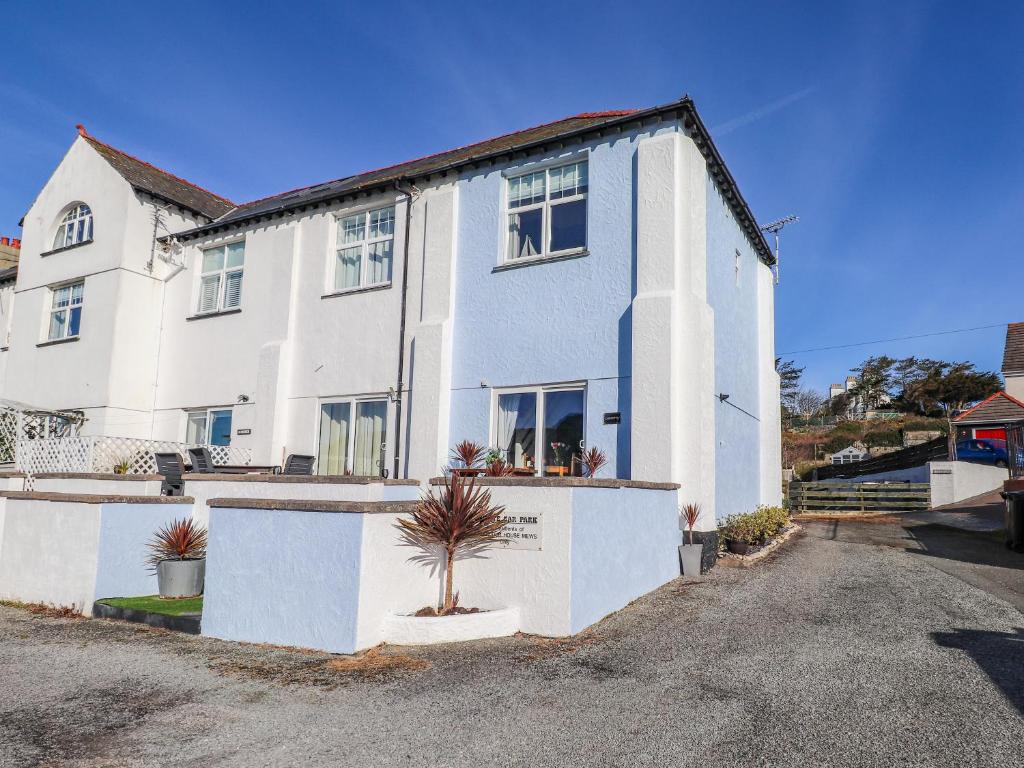 a white house with a plant in front of it at Corvette in Trearddur