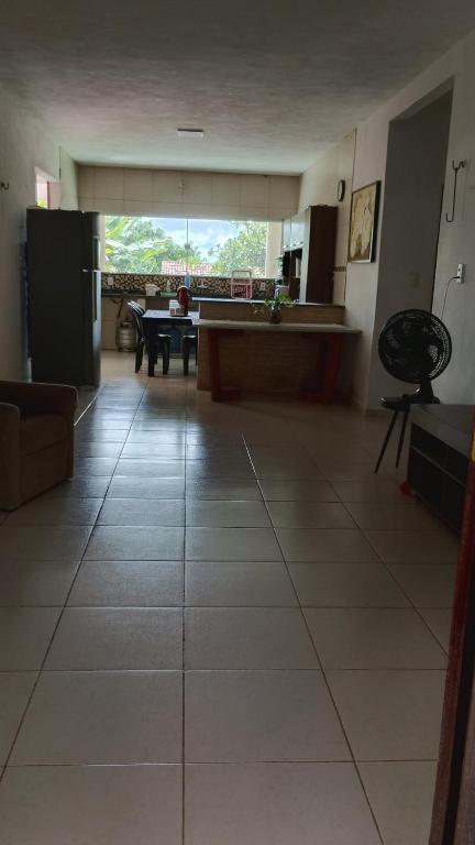a large living room with a kitchen and a table at Casa da Mari in Caucaia