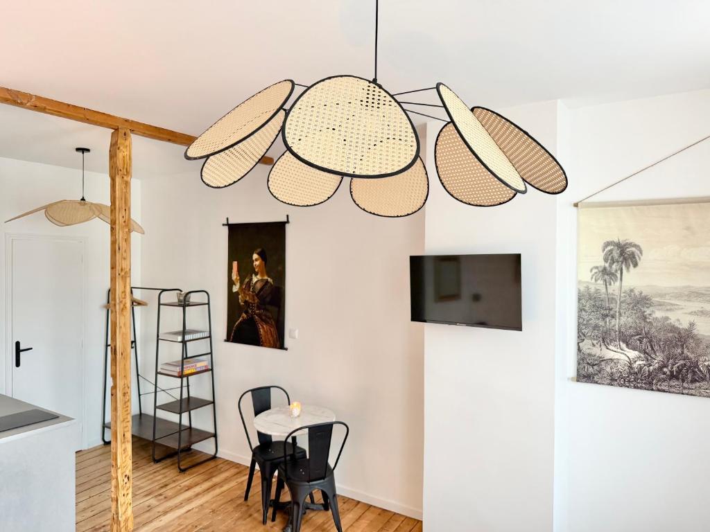 a room with a table and chairs and a chandelier at Résidence Gaïa - Etretat in Étretat