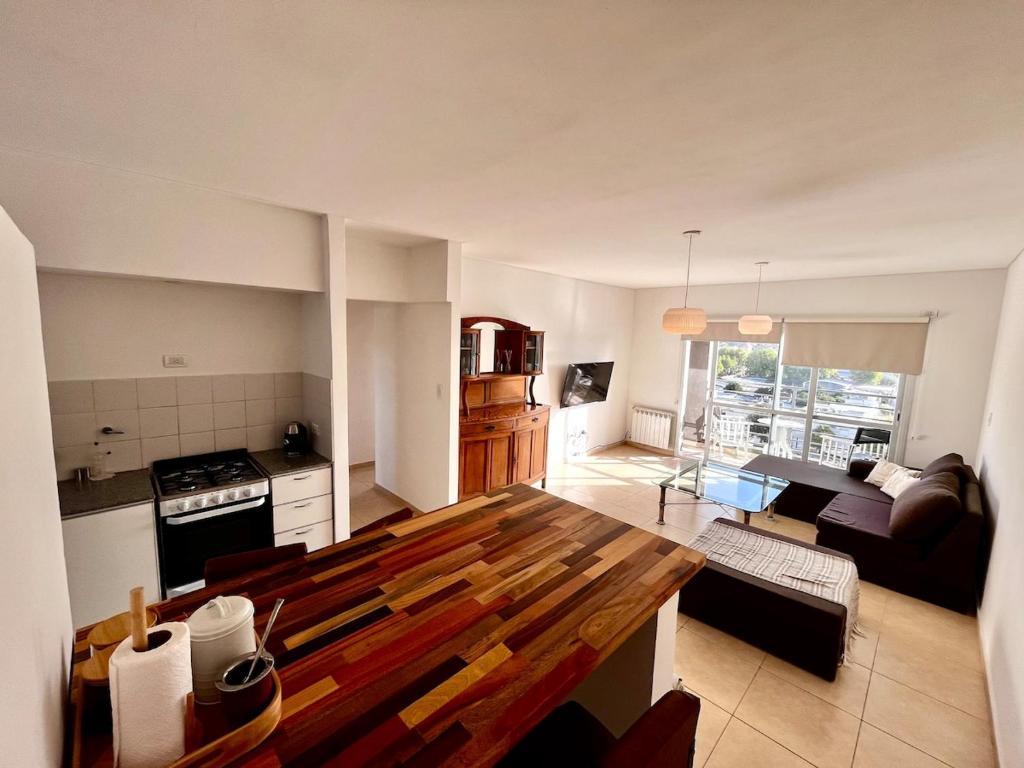 a kitchen and living room with a wooden table at Urbano Alem in Coronel Suárez