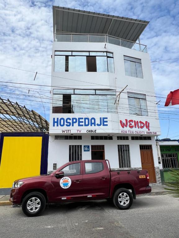 a red truck parked in front of a building at Hospedaje Wendy in Puerto Chicama