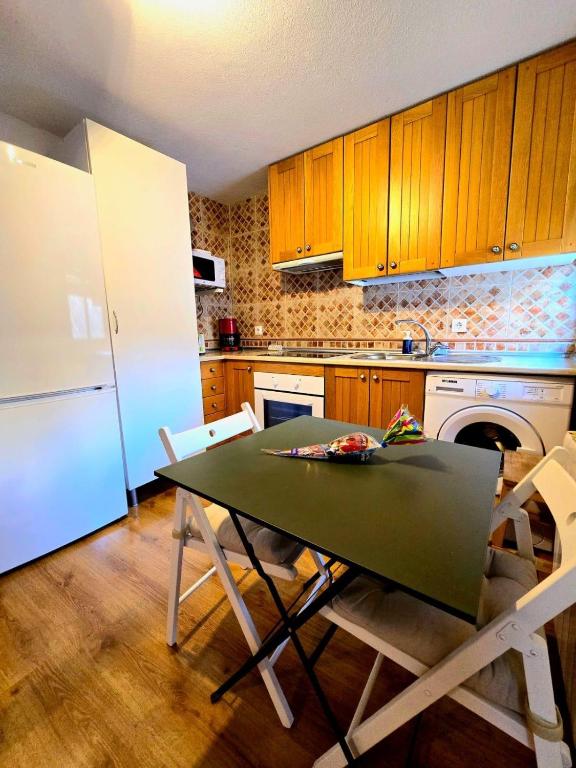 a kitchen with a green table and a white refrigerator at Toledo Histórico in Toledo