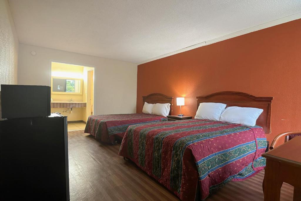 a hotel room with two beds and a flat screen tv at Vienna Travel Inn in Vienna