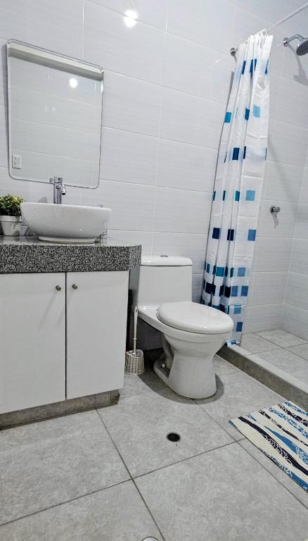 a white bathroom with a sink and a toilet at Sumaran II in Lima