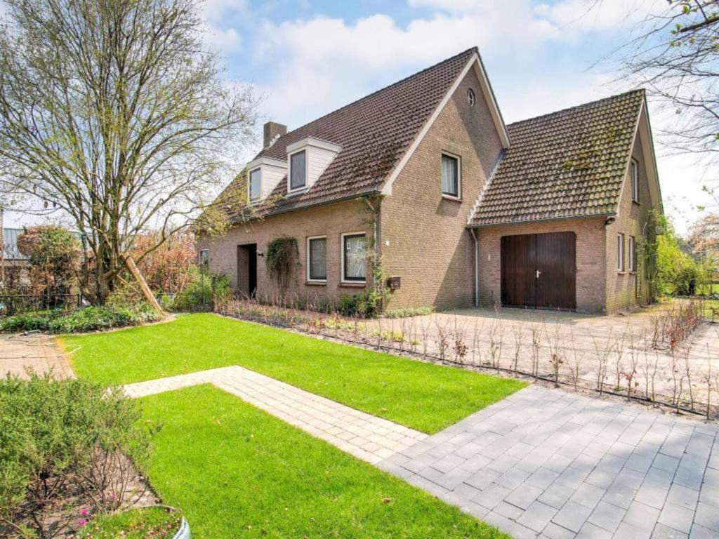 a brick house with a yard with a lawn at Steenenburg Zicht in Nieuwkuijk