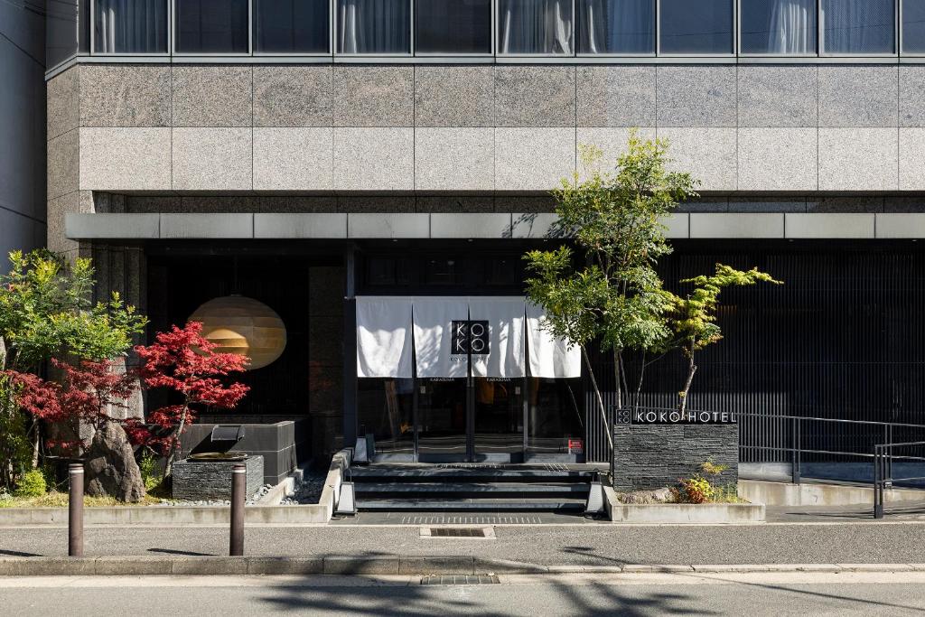 a building with a sign in front of it at KOKO HOTEL Kyoto Shijo Karasuma in Kyoto