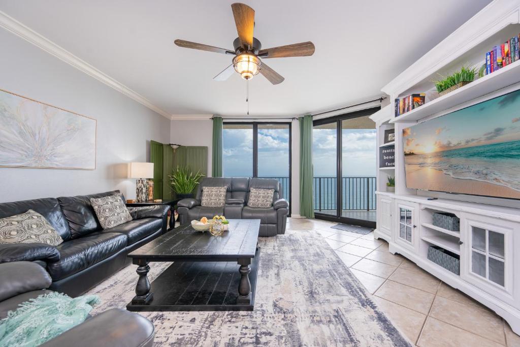 a living room with a couch and a large tv at Phoenix X 1504 condo in Orange Beach