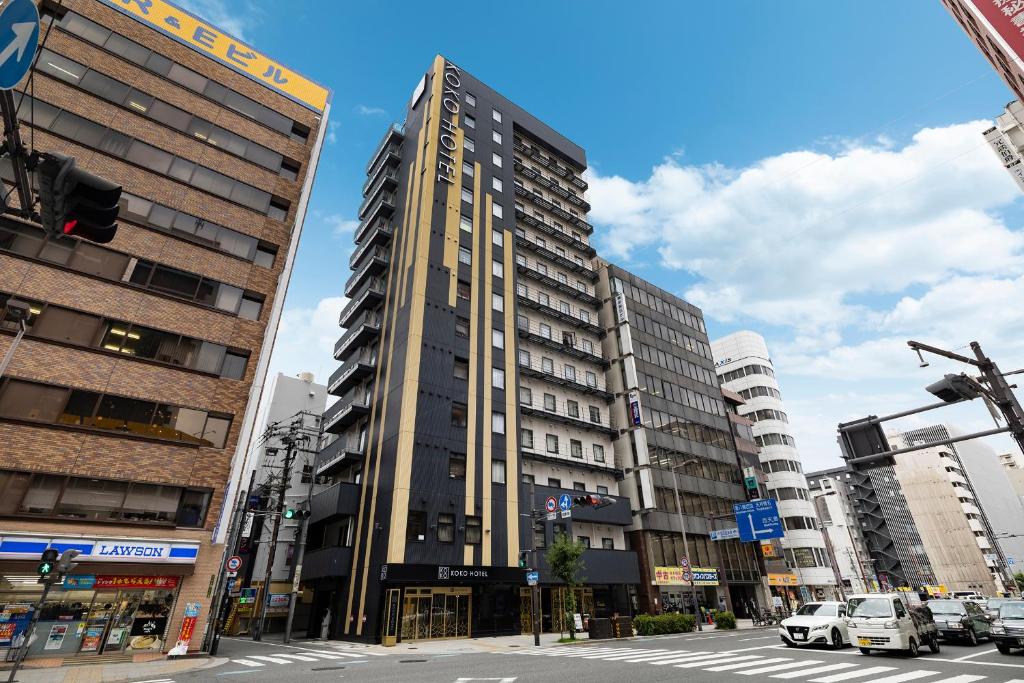 a tall building in the middle of a city at KOKO HOTEL Osaka Umeda in Osaka